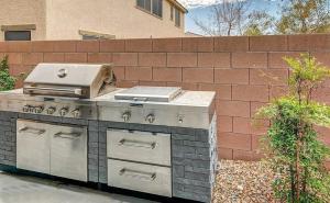 a barbecue grill in a yard next to a brick wall at The Winner's Getaway in Las Vegas
