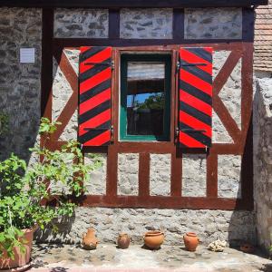 une fenêtre sur un bâtiment avec des casseroles devant lui dans l'établissement Fácán-Lak, à Nógrád