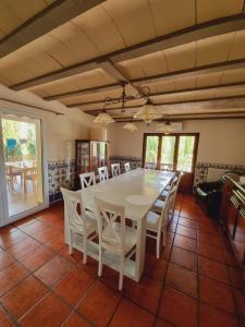 a dining room with a white table and chairs at Masia Cal Lloa in Albinyana
