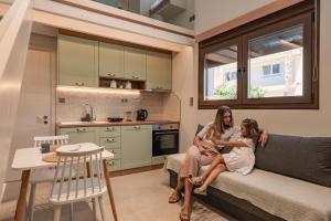 two women sitting on a couch in a kitchen at Apollo Luxury Suites in Preveza
