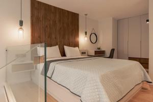 a bedroom with a bed and a glass wall at Apollo Luxury Suites in Preveza +10 photos