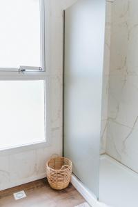 a glass shower door in a bathroom with a basket at Madero departamentos in El Bolsón +22 photos