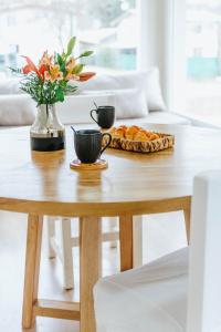 una mesa con dos tazas de café y un pastel en Madero departamentos en El Bolsón