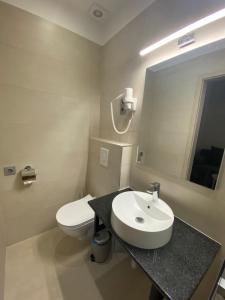 uma casa de banho com um lavatório, um WC e um espelho. em Pető Apartman em Gyor