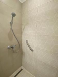uma cabina de duche na casa de banho com uma cabeça de chuveiro em Pető Apartman em Gyor