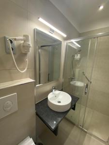 uma casa de banho com um lavatório e um chuveiro em Pető Apartman em Gyor
