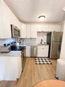 uma cozinha com armários brancos e electrodomésticos de aço inoxidável em Retreat at Fenwick em Leonardtown