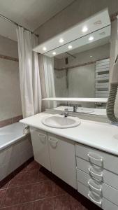 a bathroom with a sink and a mirror and a tub at T2 spacieux lumineux TIGNES VAL CLARET in Tignes