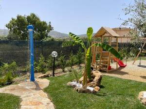 a garden with a playground and a palm tree at Casa Bea in Palmadula