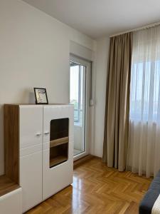 a white kitchen with a stove and a window at Apartman 24 in Ledine