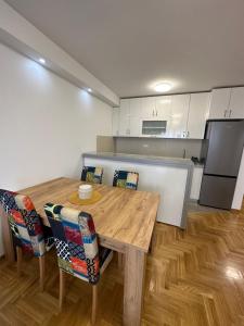 - une cuisine avec une table et des chaises en bois dans l'établissement Apartman 24, à Ledine