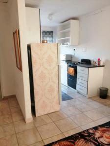 a kitchen with a refrigerator in the middle of a room at Ntindili Bed and Breakfast in De Deur