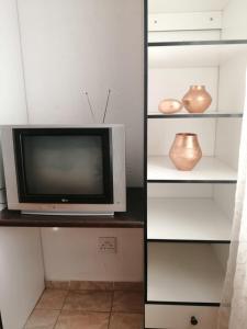 a television sitting on top of a shelf with vases at Ntindili Bed and Breakfast in De Deur