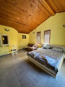 a large bedroom with a large bed and a couch at La Kameya in Kiten