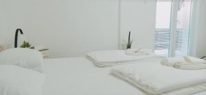 Duas camas brancas num quarto branco com uma janela em Sunčani apartman 1 em Krupanj