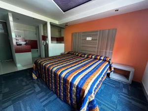 a bedroom with a bed with an orange wall at Hotel Rossel Plaza in Mexico City
