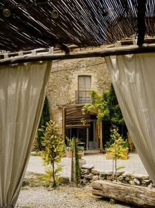 a view of a house from a window with a curtain at CAN TAT, Loft in a old coach house in Sant Jordi Desvalls