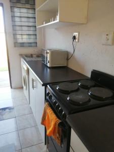 a kitchen with a black stove and a microwave at Ntindili Bed and Breakfast in De Deur