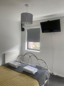 a bedroom with a bed with a flat screen tv at 2 bed house, walking distance Shrewsbury centre in Shrewsbury