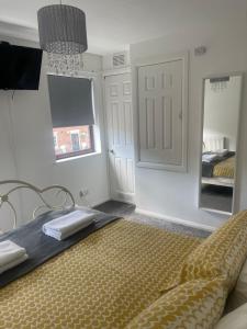 a bedroom with a bed and a mirror and a door at 2 bed house, walking distance Shrewsbury centre in Shrewsbury