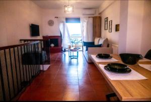 Il comprend une cuisine et un salon avec une table et un canapé. dans l'établissement #On The Rocks, à Ouranoupoli