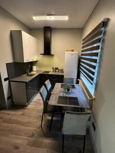 a kitchen with a table and chairs in a kitchen at ML Place 5 in Liepāja