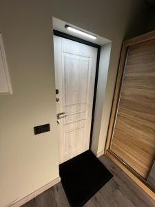a white door with a black mat in front of it at ML Place 5 in Liepāja