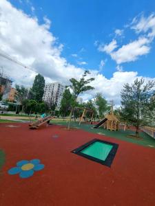 un parc avec une aire de jeux avec un toboggan et des balançoires dans l'établissement 21 Residence Studio, à Bucarest