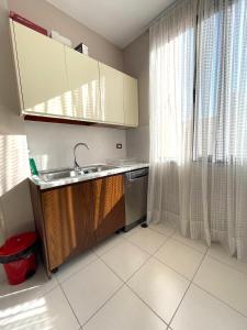 een kleine keuken met een wastafel en een raam bij Brand New Apartament Durres in Durrës
