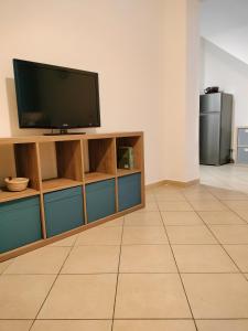 a living room with a flat screen tv on a cabinet at Casa Kalé in Aci Castello