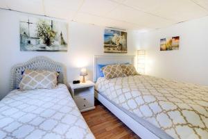 a bedroom with two beds and a night stand at 1 Ocean Fun Emerald Isle Apt, Steps to Beaches! in Emerald Isle