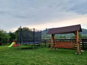 a park with a bench and a canopy and a playground at Popasul Găleșean in Galeşu