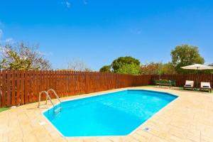 una piscina frente a una valla de madera en Yiangos House, en Neo Chorio