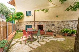 un patio con mesa y sillas bajo una sombrilla en APPARTAMENTI LE GINESTRE 10, en Murlo