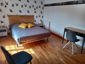 a bedroom with a bed and a desk and a chair at Maison de caractère Caprice Normand, jardin clos, 7min à pied des plages in Langrune-sur-Mer