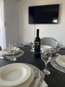een fles wijn op een tafel met glazen bij Apartman FILIP in Podstrana