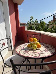 een tafel met een fruitschaal op een balkon bij Apartman FILIP in Podstrana