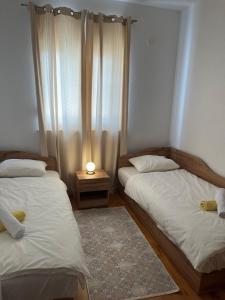 een slaapkamer met 2 bedden en een lamp op een tafel bij Apartman FILIP in Podstrana