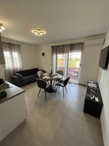een keuken en een woonkamer met een tafel en stoelen bij Apartman FILIP in Podstrana