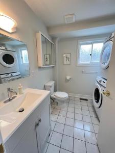 a bathroom with a sink and a washing machine at Letitia Heights !A Spacious and Quiet Private Bedroom with Shared Bathroom in Barrie