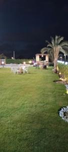 eine Gruppe Picknicktische in einem Park in der Nacht in der Unterkunft فيلا للايجار في مارينا 4 حمام سباحة خاص in El-Alamein
