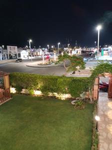 a yard with a green hedge and a street at night at فيلا للايجار في مارينا 4 حمام سباحة خاص in El Alamein