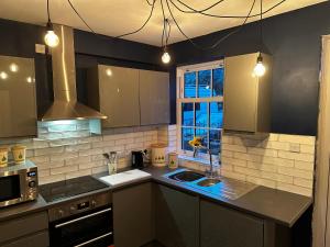 a kitchen with a sink and a stove top oven at Grammar School Yard in Hull