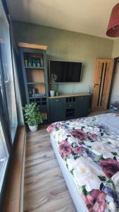 a bedroom with a bed with a floral comforter and a television at Apartment in city center in Przemyśl