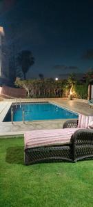 ein Schwimmbad in der Nacht mit einer Couch im Gras in der Unterkunft فيلا للايجار في مارينا 4 حمام سباحة خاص in El-Alamein