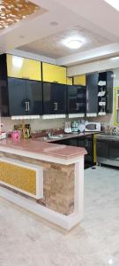a large kitchen with black and yellow cabinets at فيلا للايجار في مارينا 4 حمام سباحة خاص in El Alamein