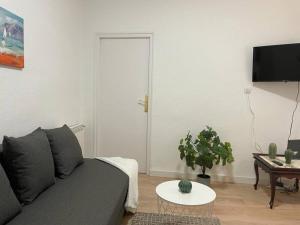 a living room with a gray couch and a table at AR2 Luminoso piso de 3 habs con balcón y WIFI in Madrid