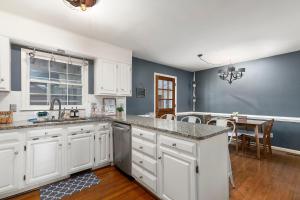 een keuken met witte kasten en een eetkamer bij Cozy & Relaxing Home, Hot Tub, Fire Pit, Deck in Greensboro