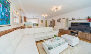 a living room with a white couch and a tv at Dubrovnik Luxury Residence – L’Orangerie in Dubrovnik