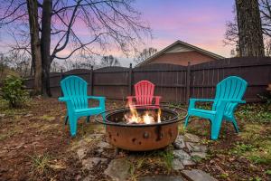 drie stoelen rond een vuurplaats in een tuin bij Cozy & Relaxing Home, Hot Tub, Fire Pit, Deck in Greensboro